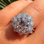 Diamond ring on a person's finger with a blurred natural background