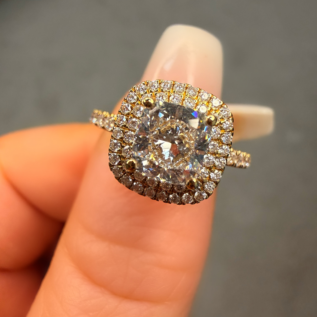 Diamond ring held on a finger against a neutral background