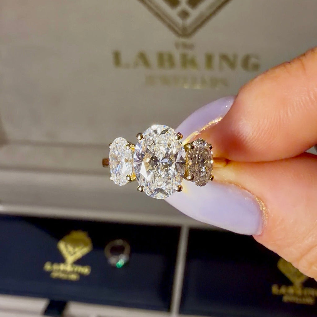 Diamond ring held by a hand with 'The Lab King' branding in the background.