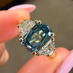 Ring with a blue gemstone held between fingers