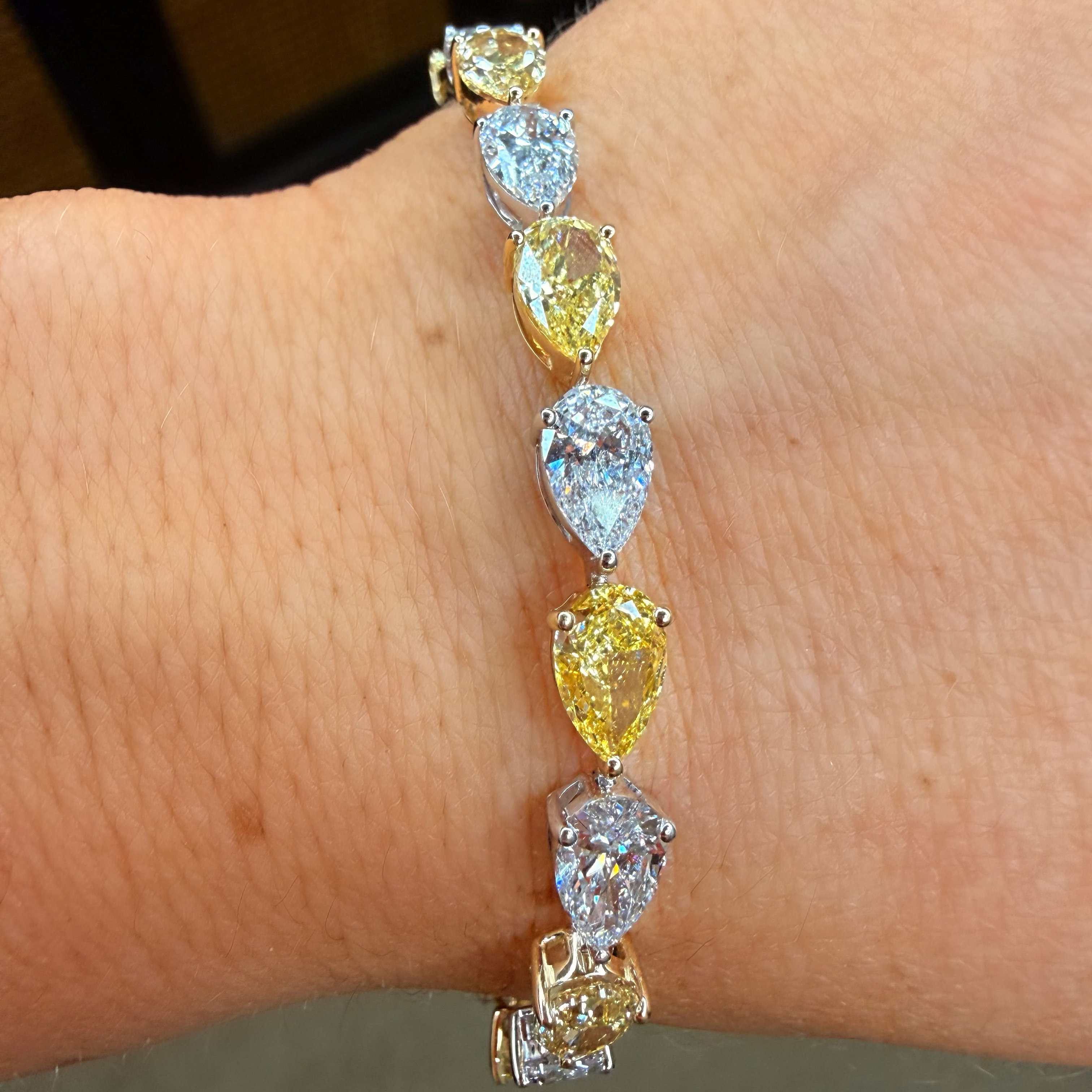 Diamond bracelet on a wrist with a neutral background