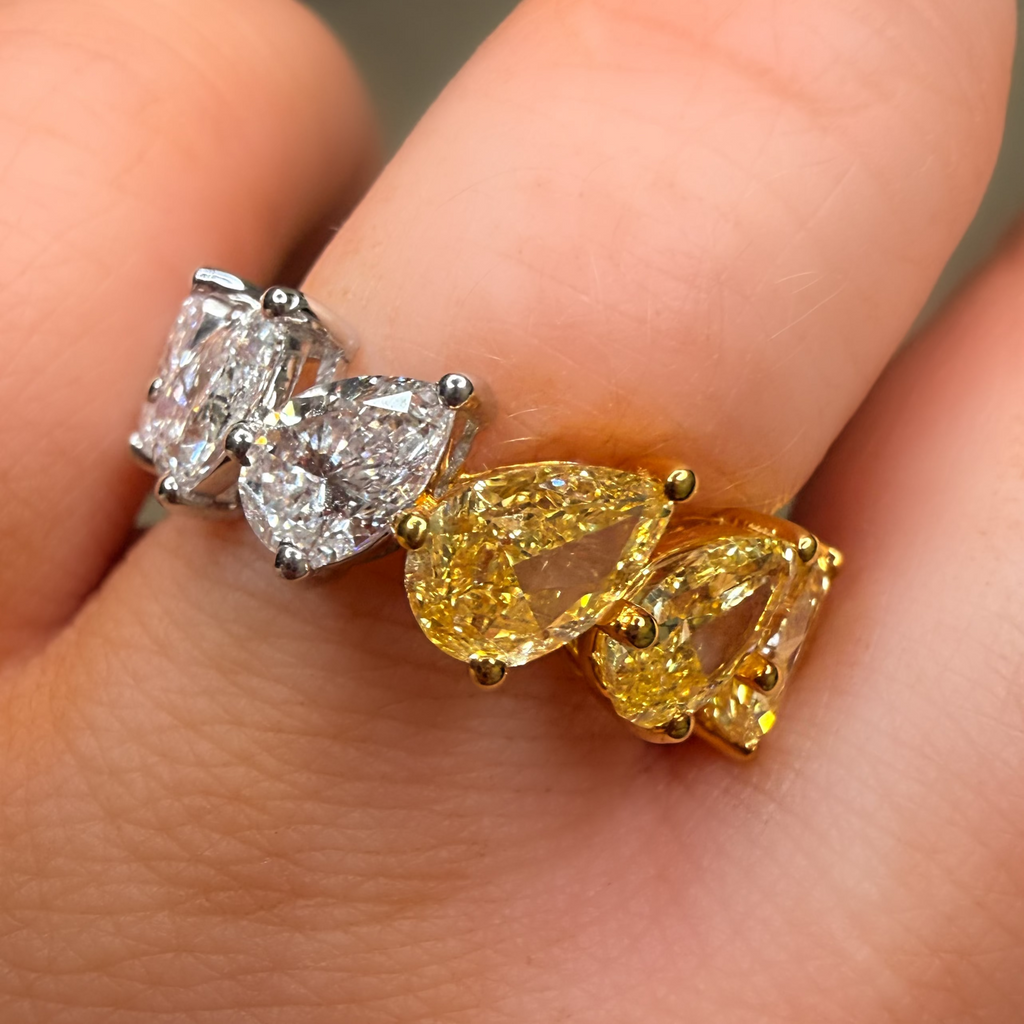 Two diamond earrings being held between fingers
