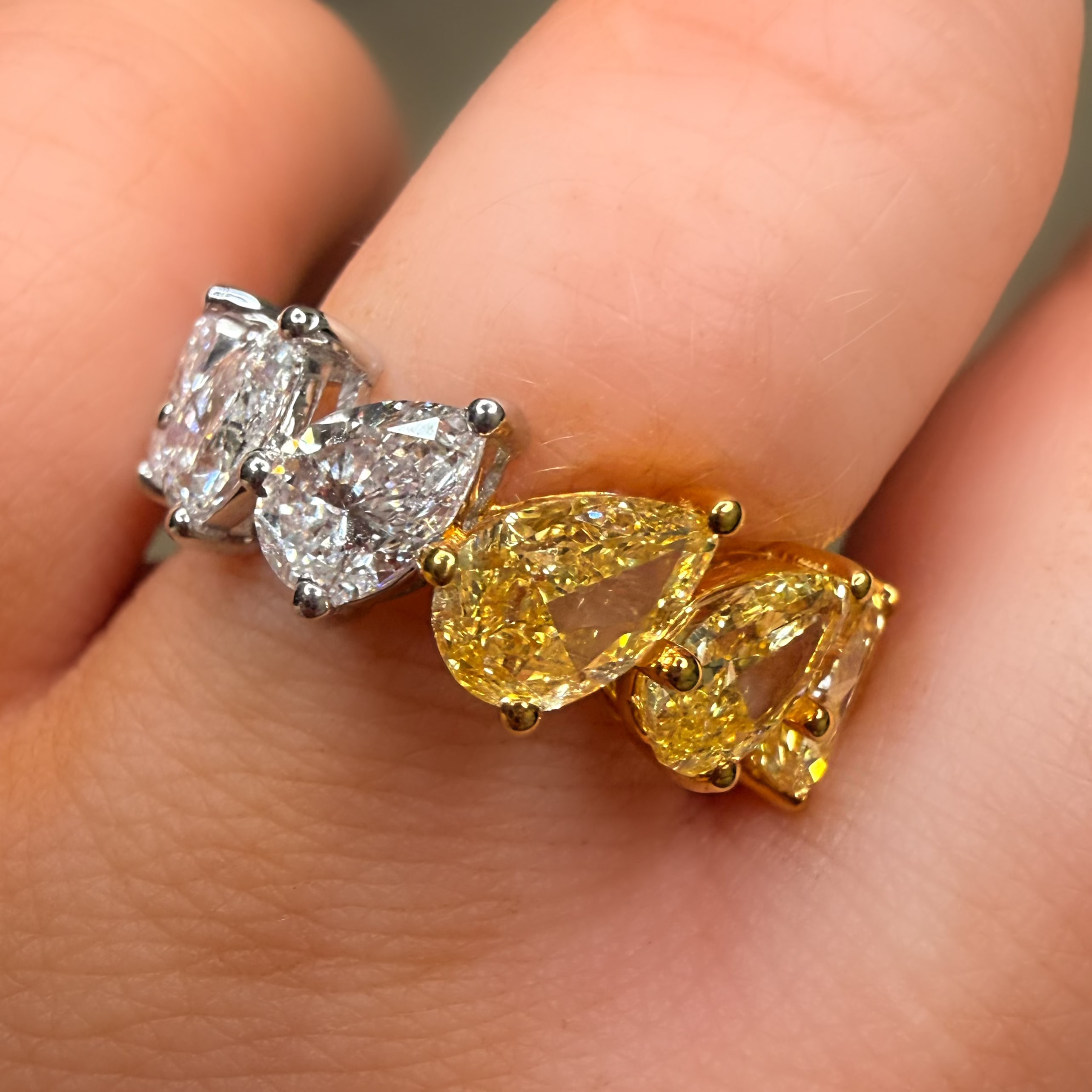 Two diamond earrings being held between fingers