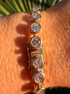 Gold bracelet with diamonds on a wrist against a natural background