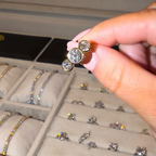 Person holding a diamond ring with a jewelry box in the background