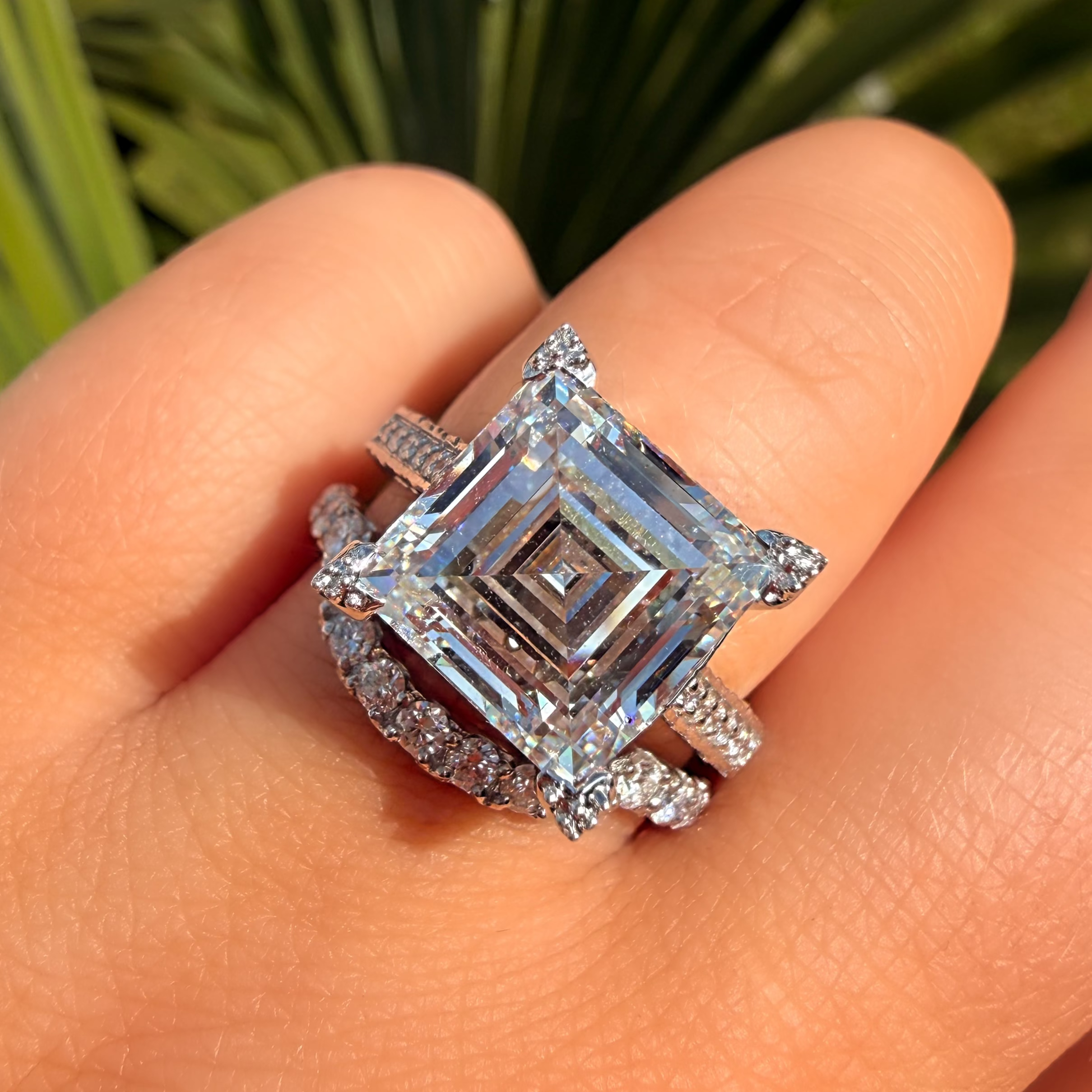 Diamond ring on a finger with a blurred green background