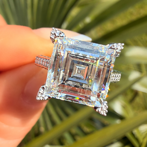 Diamond ring held by a hand with a natural background