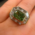 Ring with a green gemstone on a person's finger