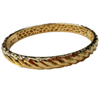 Gold bracelet on a textured surface with gold text