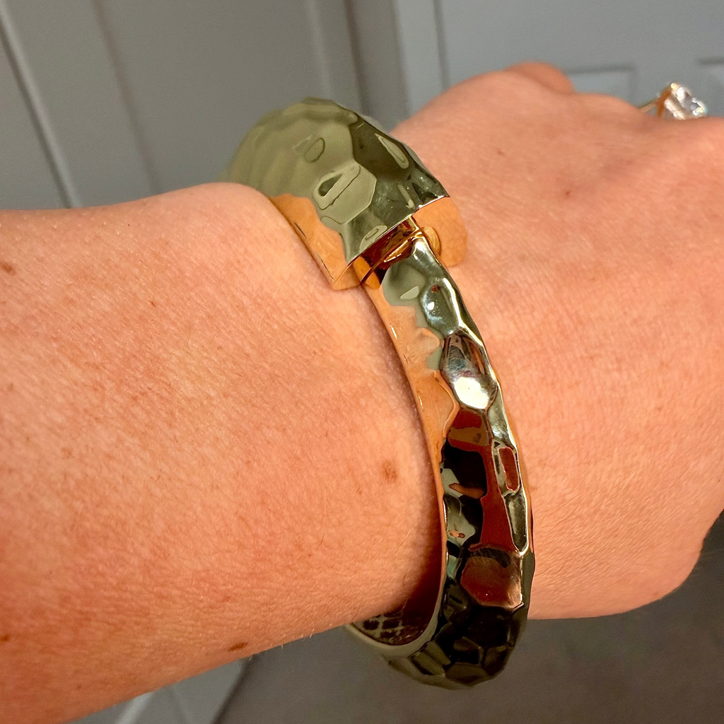 Bracelet on a wrist with a neutral background