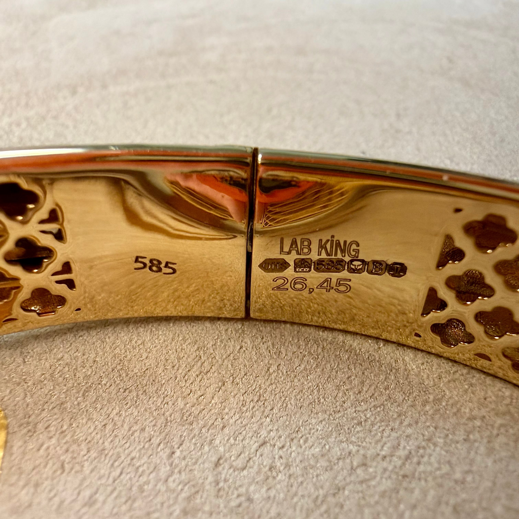Gold bracelet with 'LAB KING' branding on a textured surface