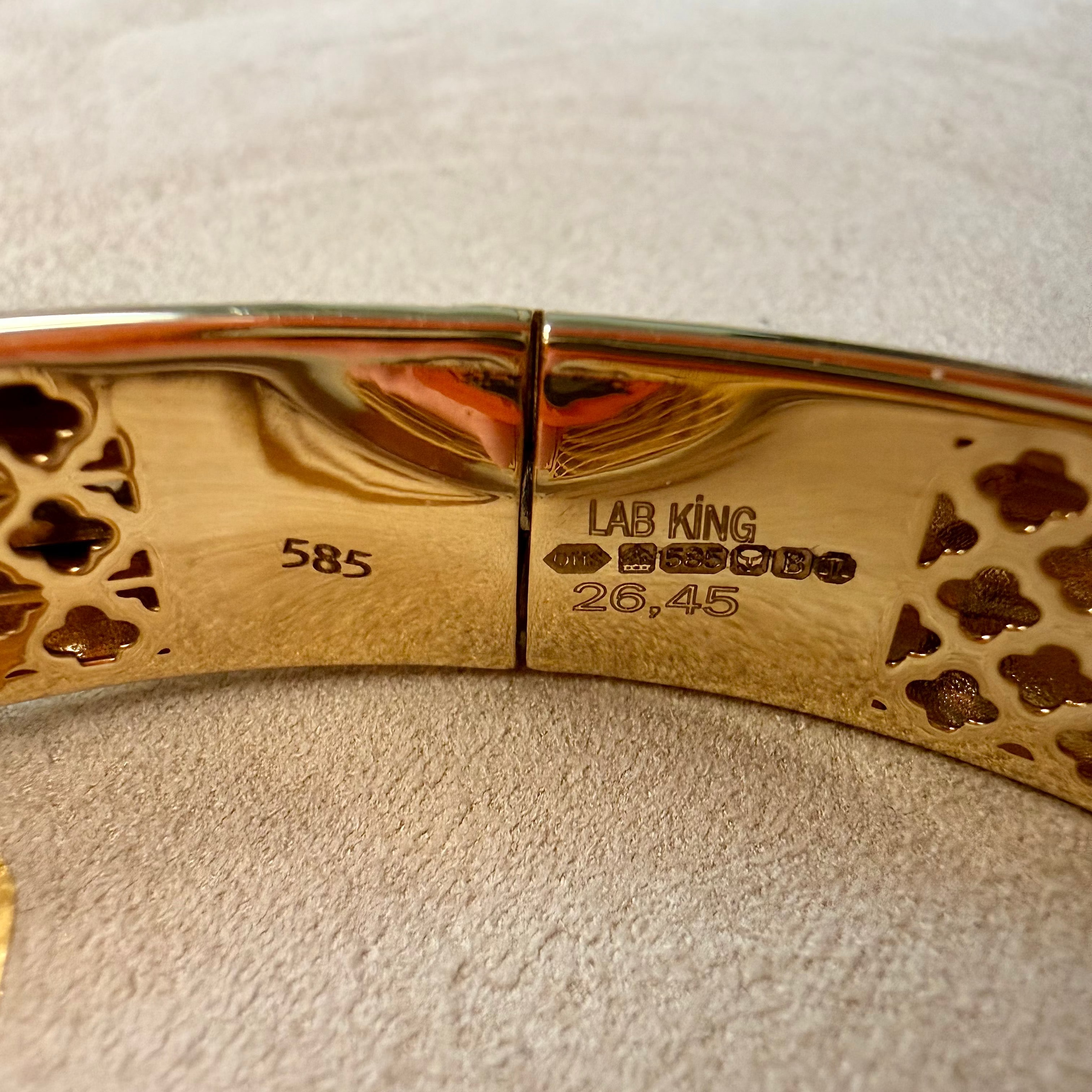 Gold bracelet with 'LAB KING' branding on a textured surface