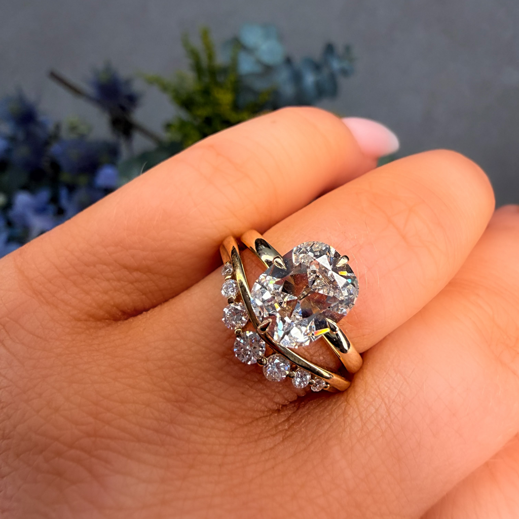 Gold and silver ring with diamonds on a hand against a blurred natural background