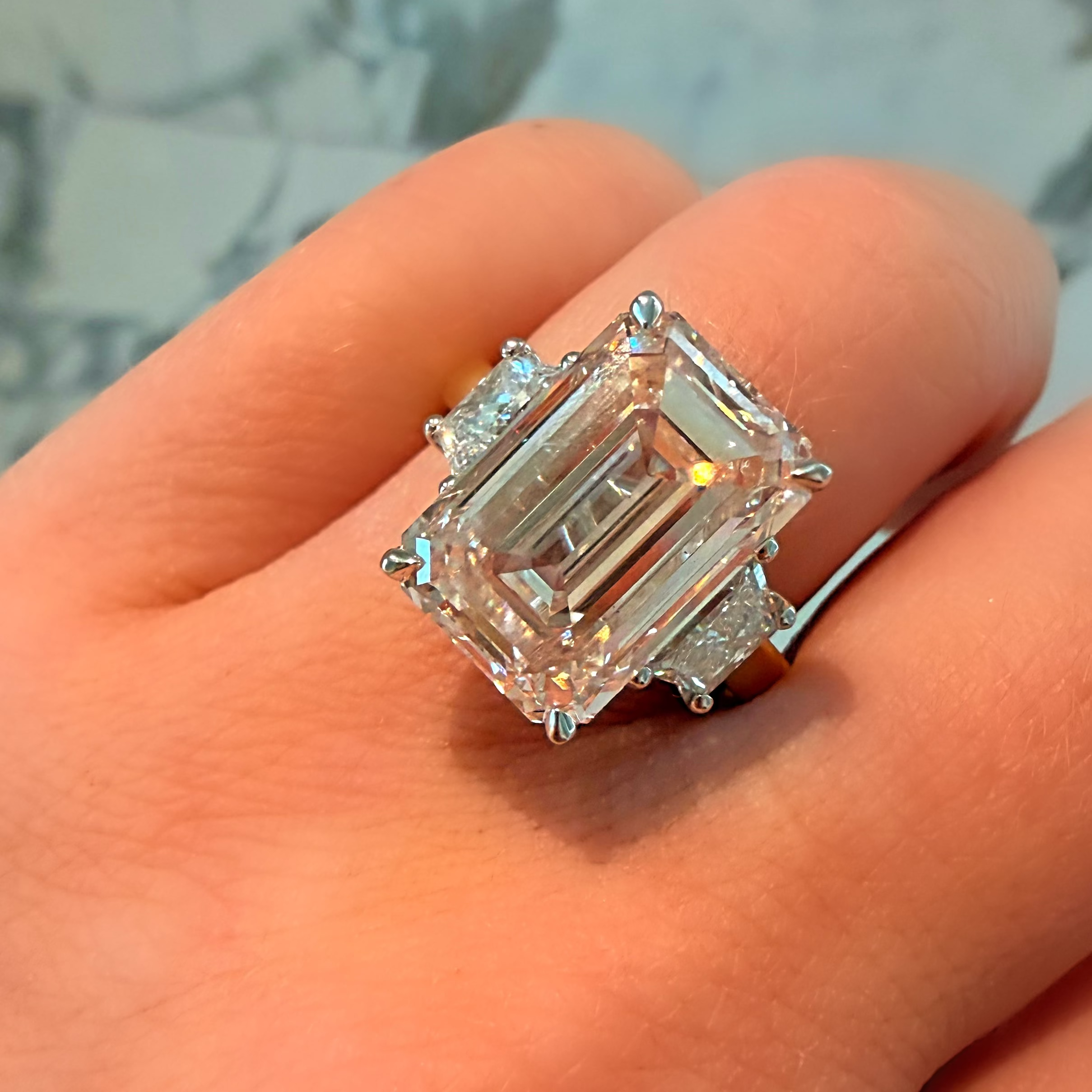 Diamond ring held on a hand with a blurred background