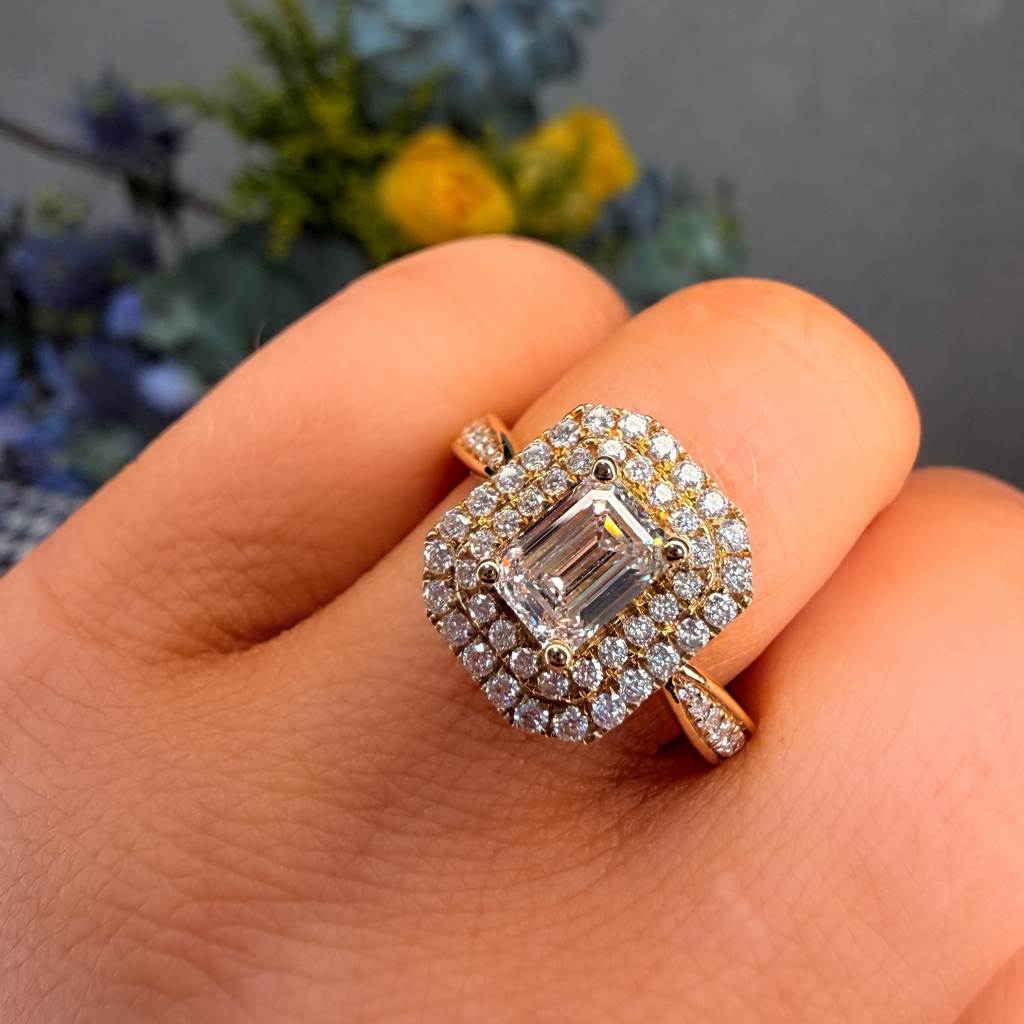 Diamond ring on a hand with a blurred floral background