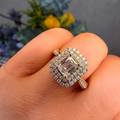 Diamond ring on a hand with a blurred floral background