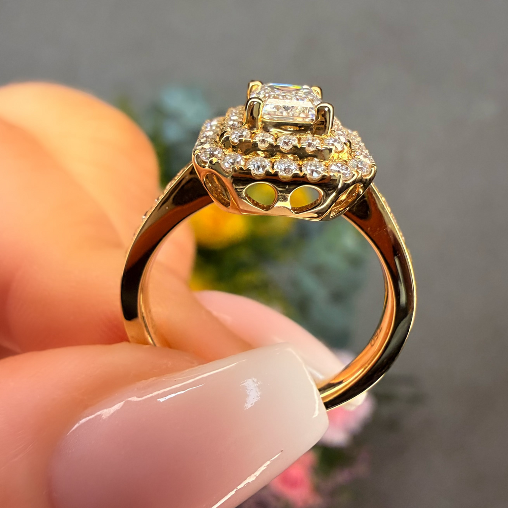 Gold ring with diamonds held by a hand against a blurred background