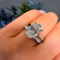 Diamond ring on a hand with a blurred floral background