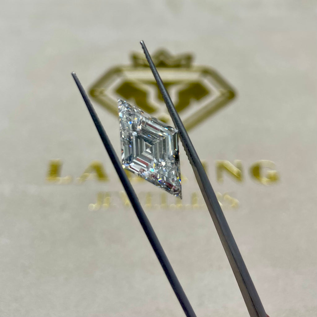 Diamond held between two tweezers with a Lanson logo in the background