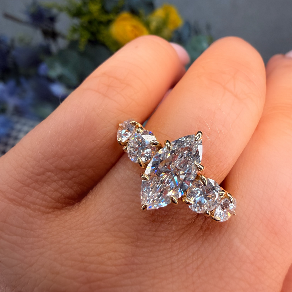 Diamond ring on a finger with a blurred floral background