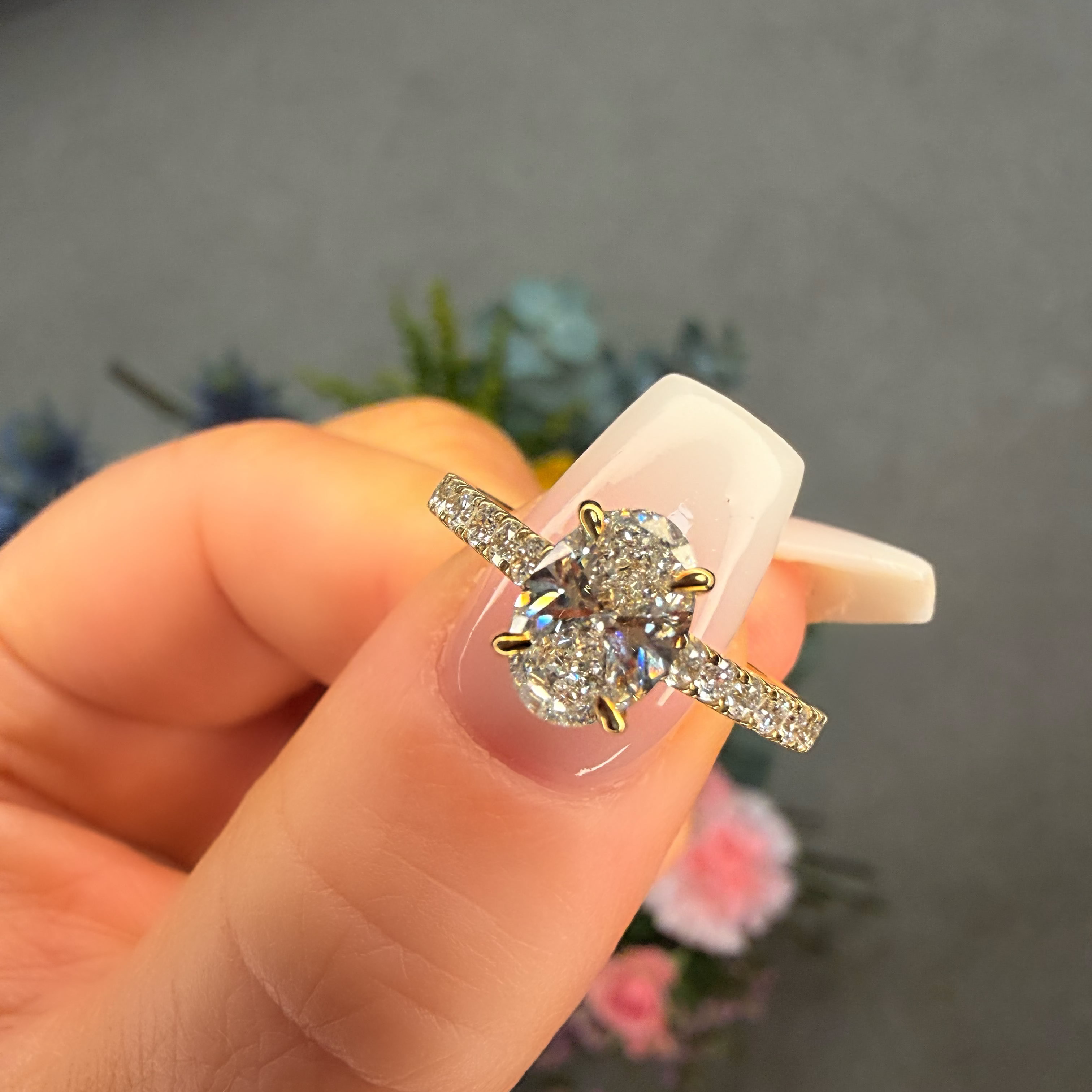 Diamond ring held in a hand with a blurred background