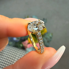 Diamond ring held between fingers with a blurred background