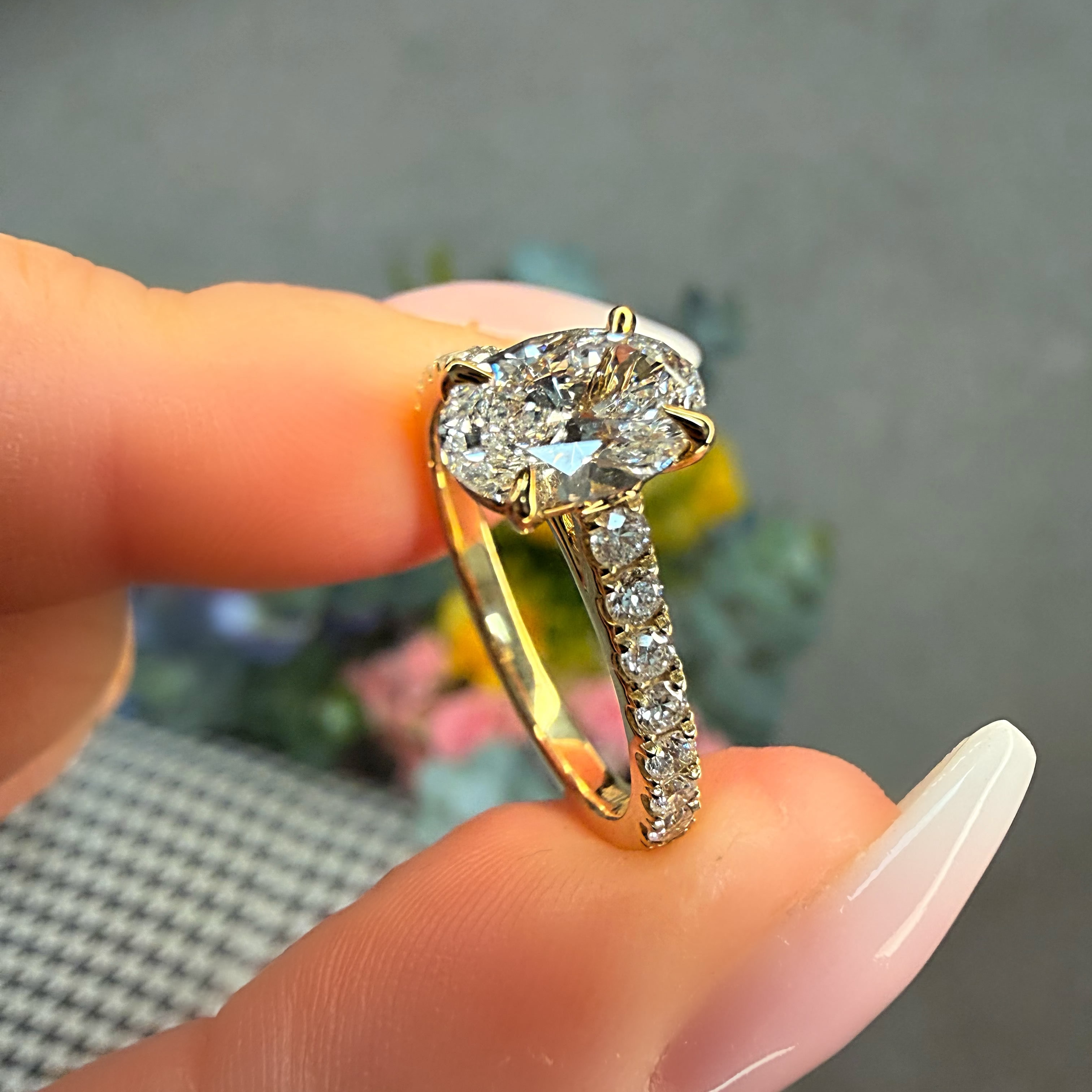 Diamond ring held between fingers with a blurred background