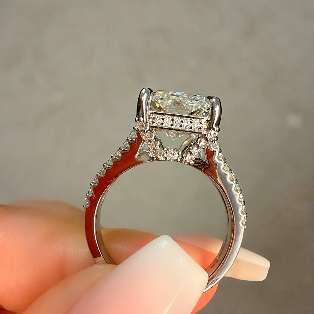 Diamond ring held between fingers against a neutral background