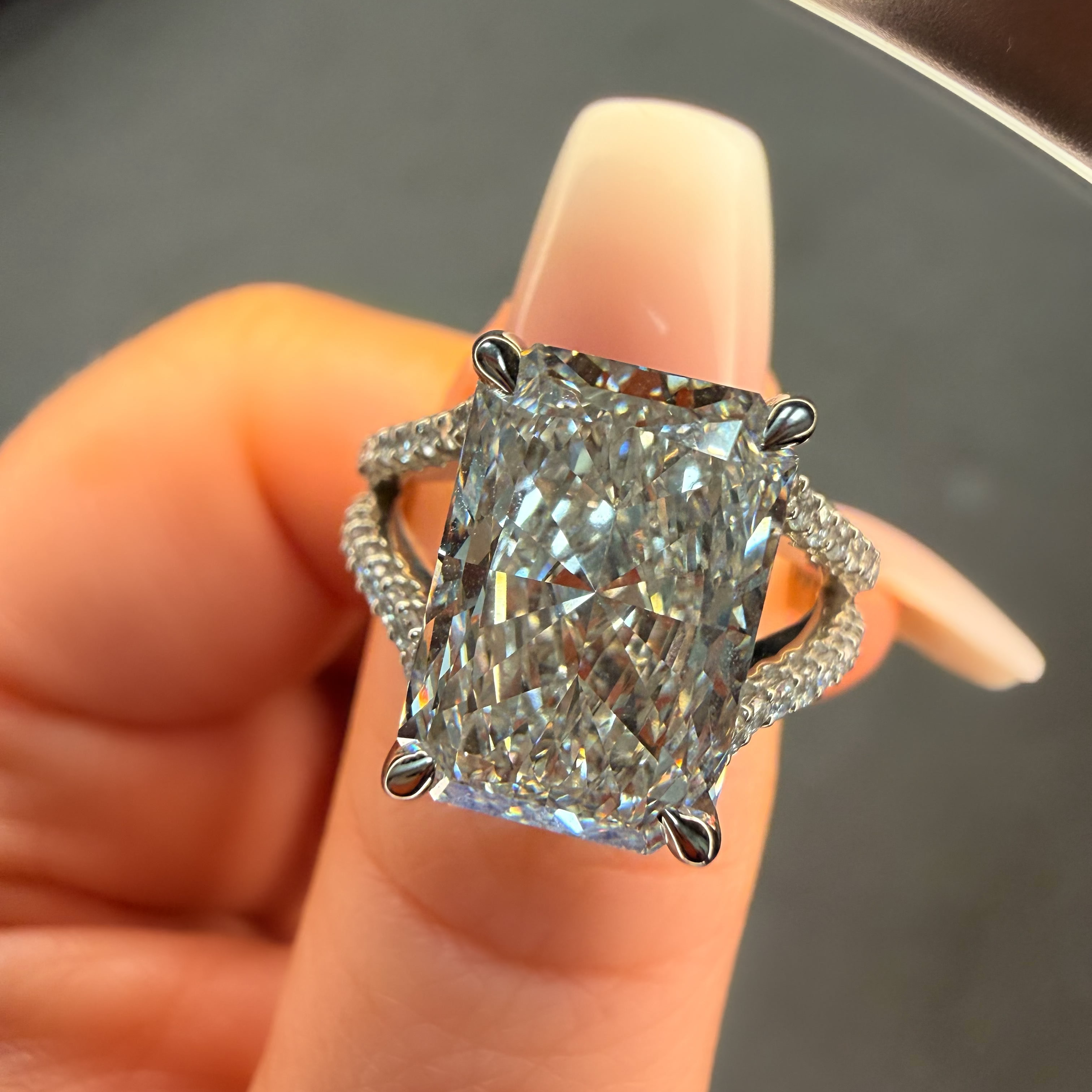 Diamond ring held on a finger with a blurred background