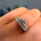 Diamond ring on a finger with a blurred natural background