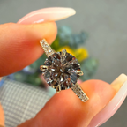 Diamond ring held between fingers with a blurred background