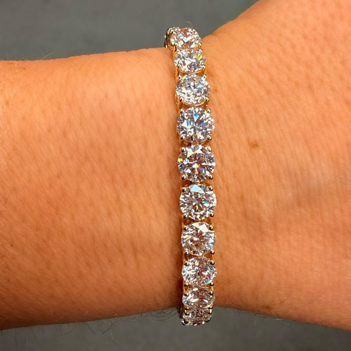 Diamond bracelet on a wrist against a neutral background