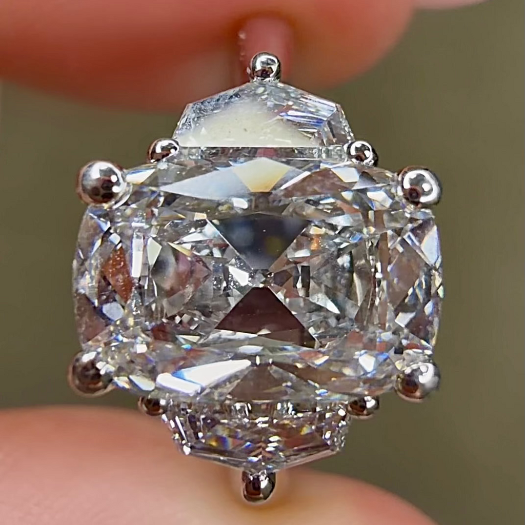 Close-up of a diamond earring held between fingers with a blurred background