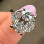 Diamond ring held between fingers with a blurred background