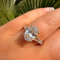 Diamond ring on a hand with a blurred green leafy background