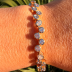 Close-up of a person's wrist wearing a diamond bracelet with a natural background.