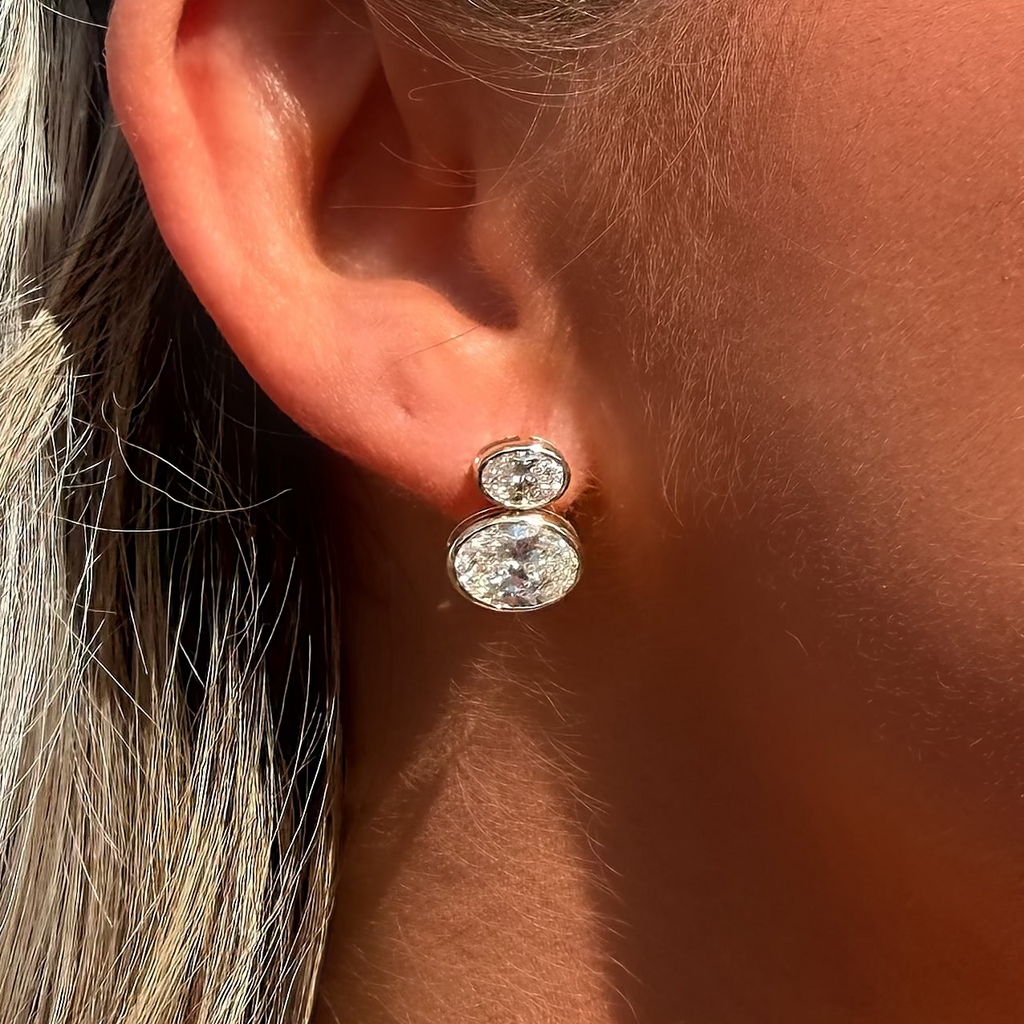 Close-up of an ear wearing a diamond earring with a blurred background