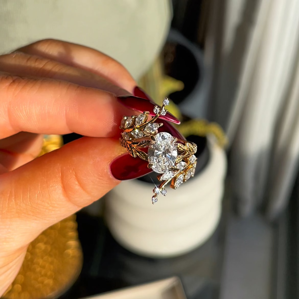 Gold ring with diamonds held by a hand, blurred background