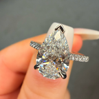 Diamond ring held in a hand with a blurred background