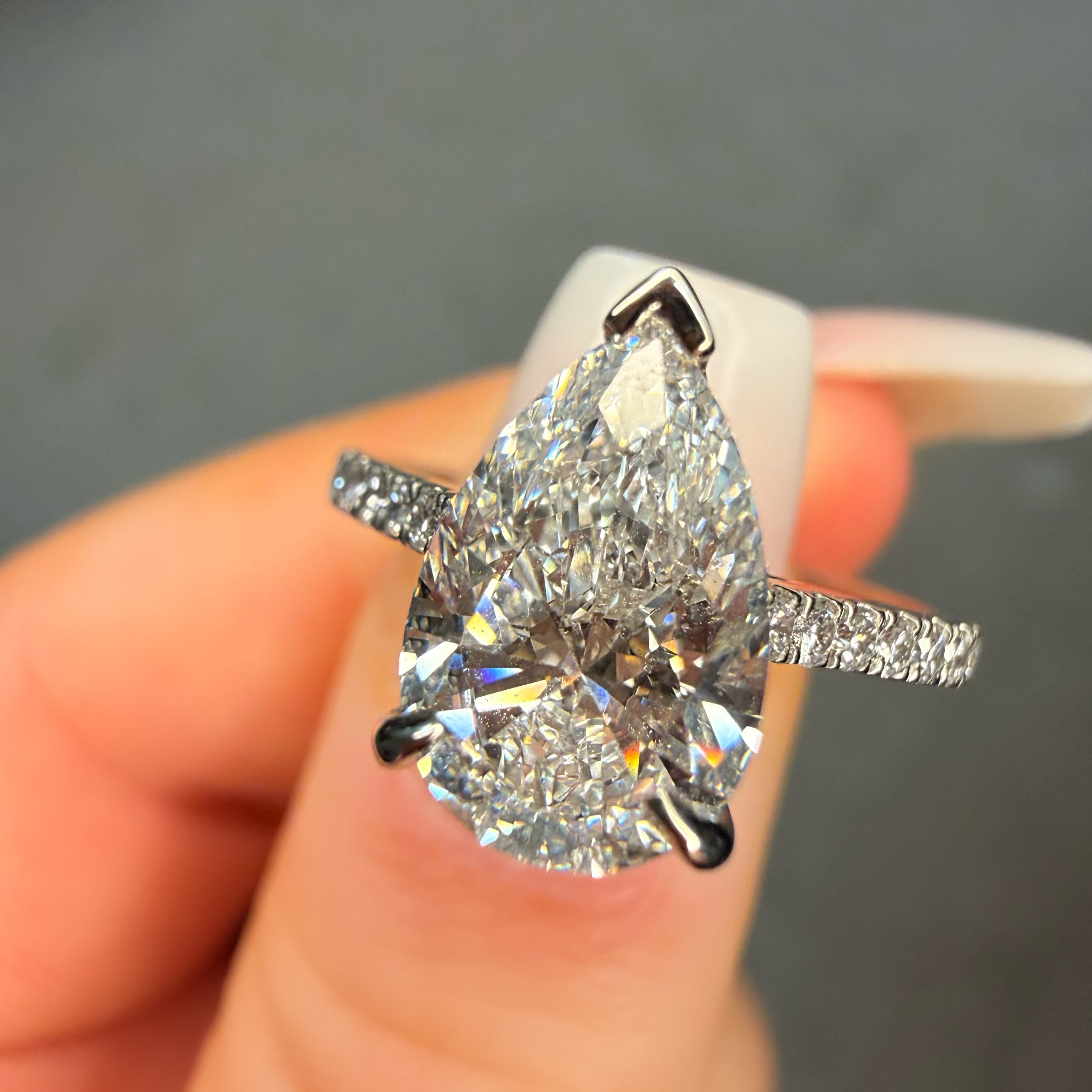 Diamond ring held in a hand with a blurred background