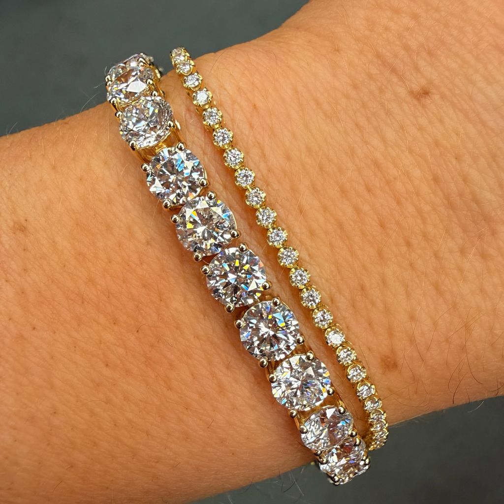 Gold bracelet with clear gemstones on a wrist against a neutral background