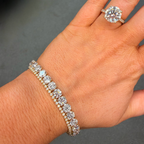 Hand wearing a diamond bracelet and ring on a dark background