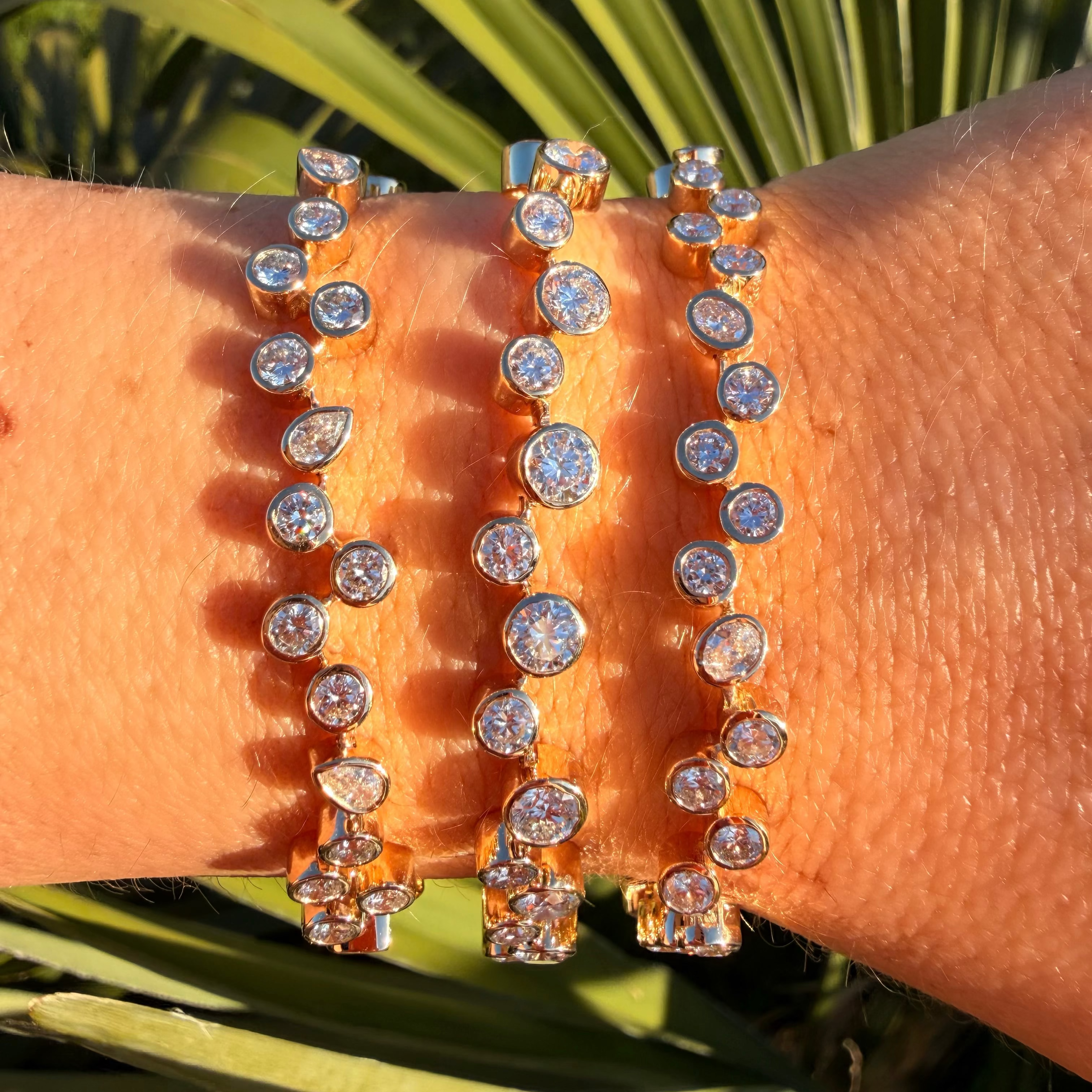 Close-up of a wrist wearing multiple sparkling bracelets with a natural background