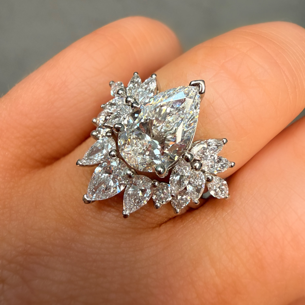 Diamond ring held on a hand against a neutral background