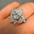 Diamond ring held on a hand against a neutral background