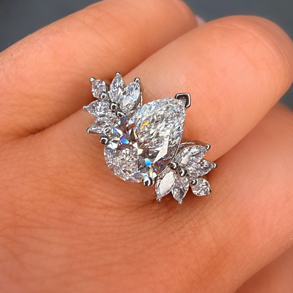 Diamond earring on a finger against a neutral background