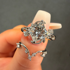 Silver ring with a large diamond on a hand against a dark background