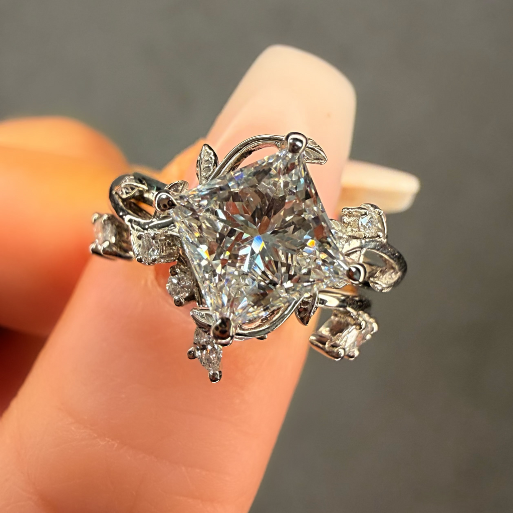 Diamond ring held on a finger against a neutral background