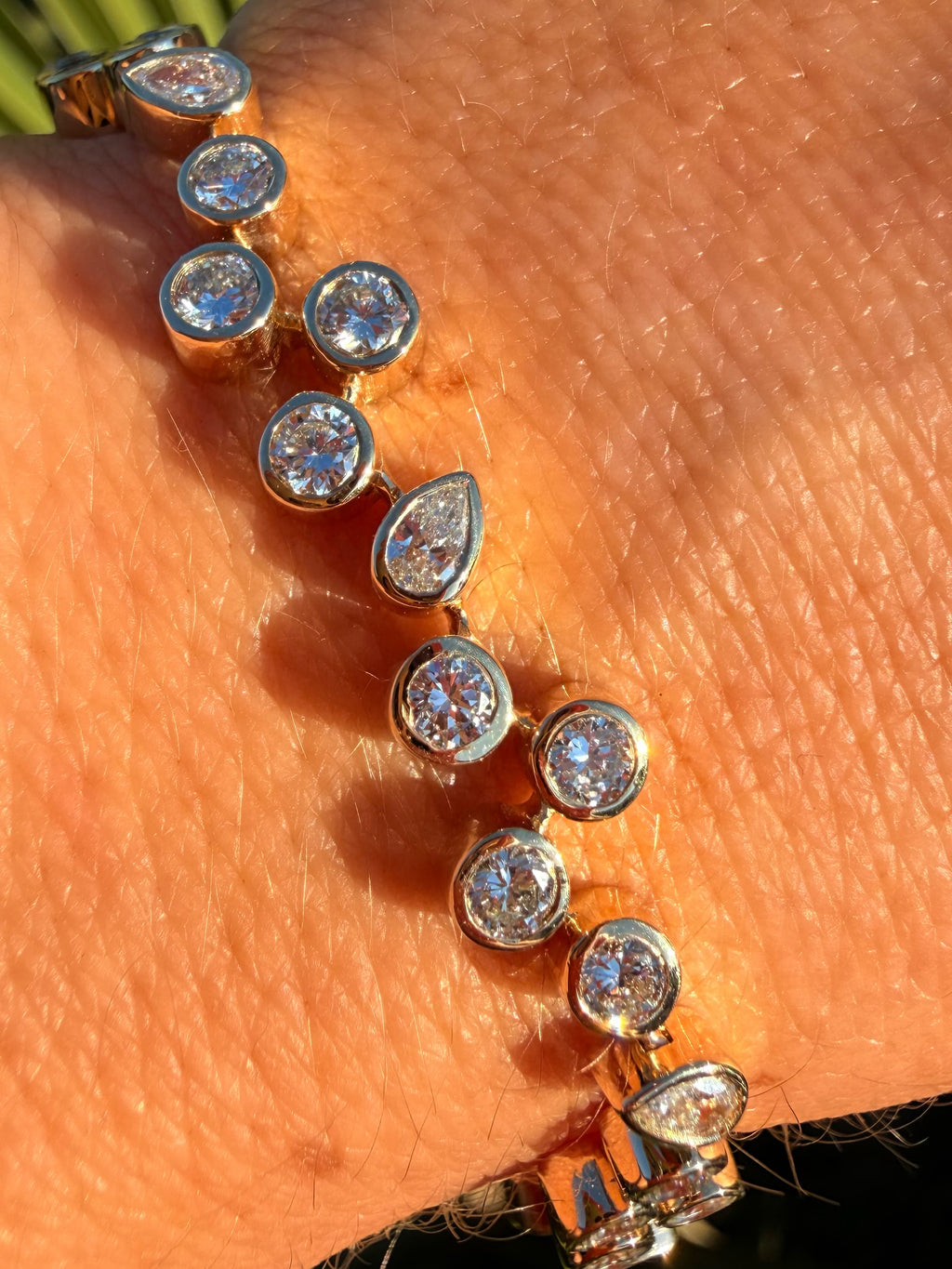 Gold bracelet with clear stones on a person's wrist