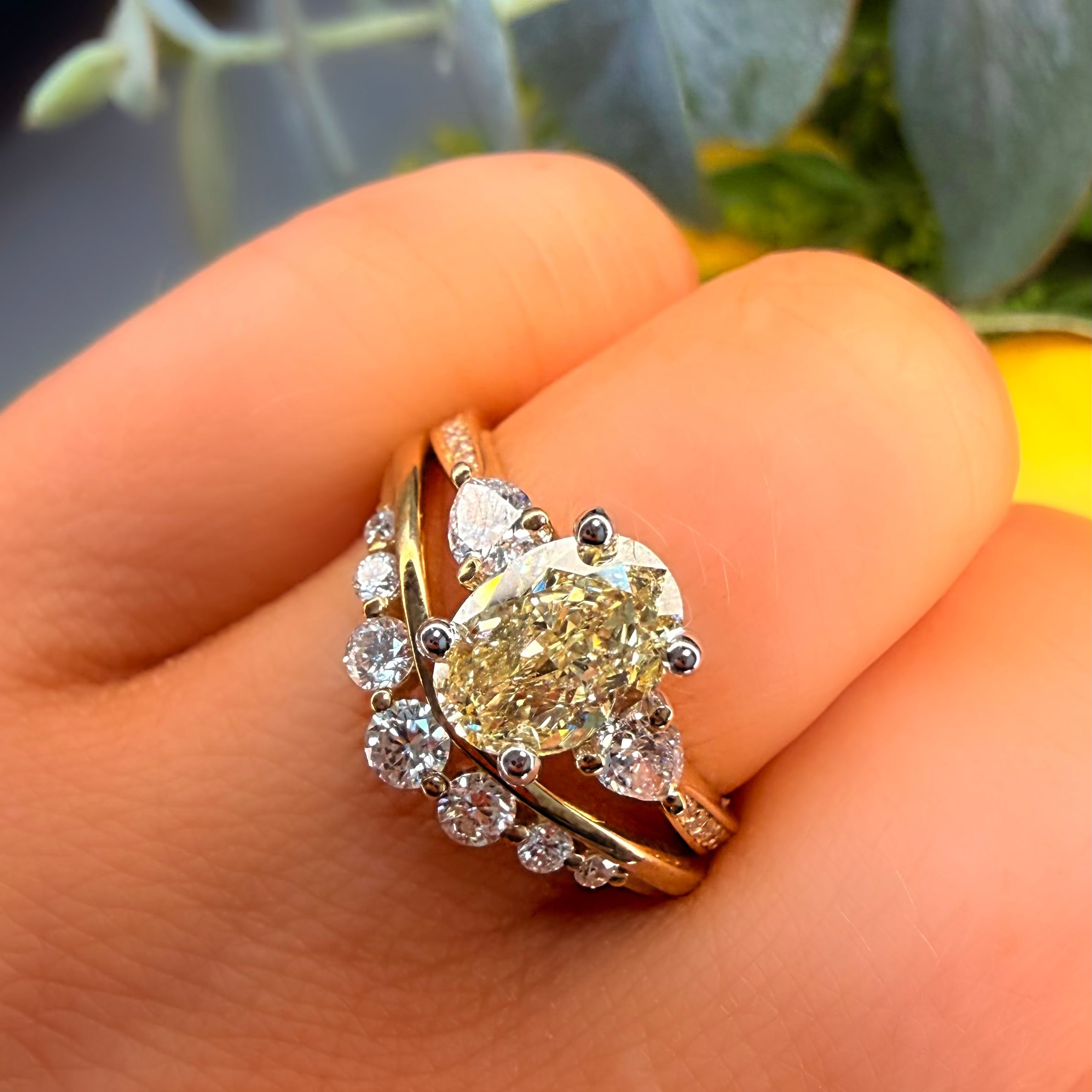 Gold ring with a large diamond on a hand with a blurred natural background